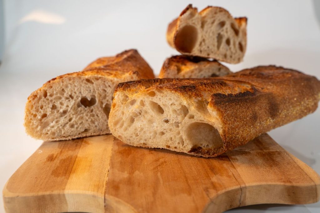 Close-up of freshly baked artisanal bread slices on a wooden board.
