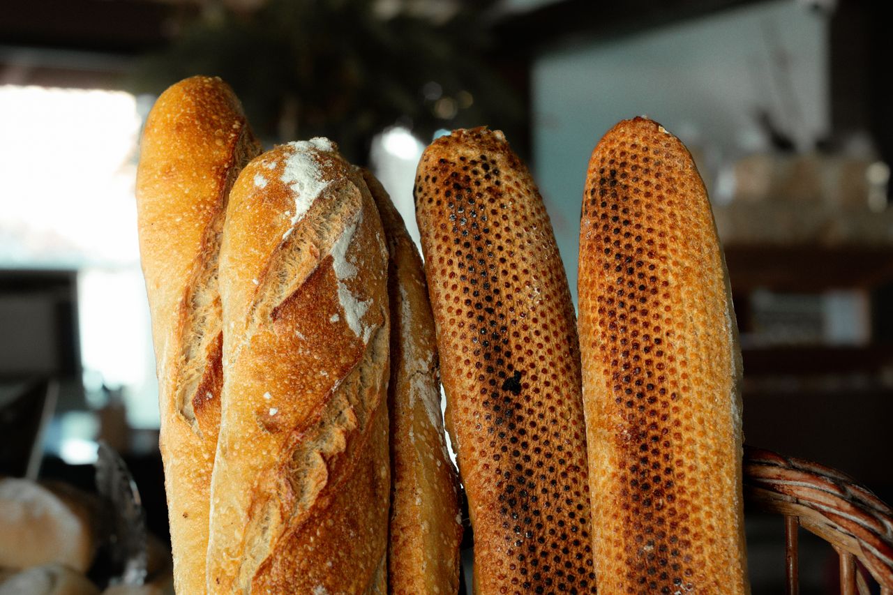 Close-up of artisan baguettes on display in a São Paulo bakery, showcasing crusty textures.